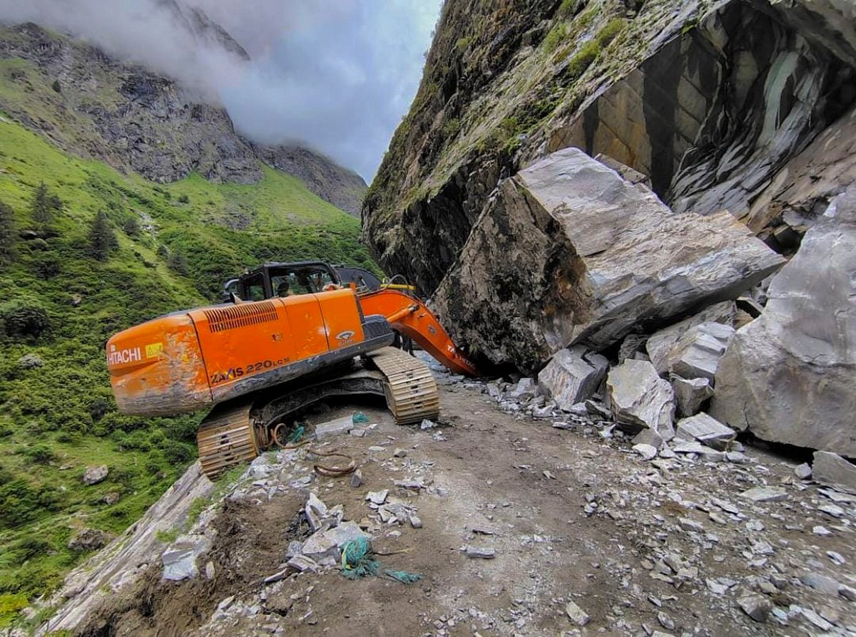 PTI : The Badrinath National Highway blocked after a boulder fell on an excavator machine, from a hill at Ghudsil, near Hanuman Chatti, in Chamoli district, Monday, July 8, 2024. 